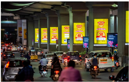 Metro pillars with yellow advertisements and traffic at night